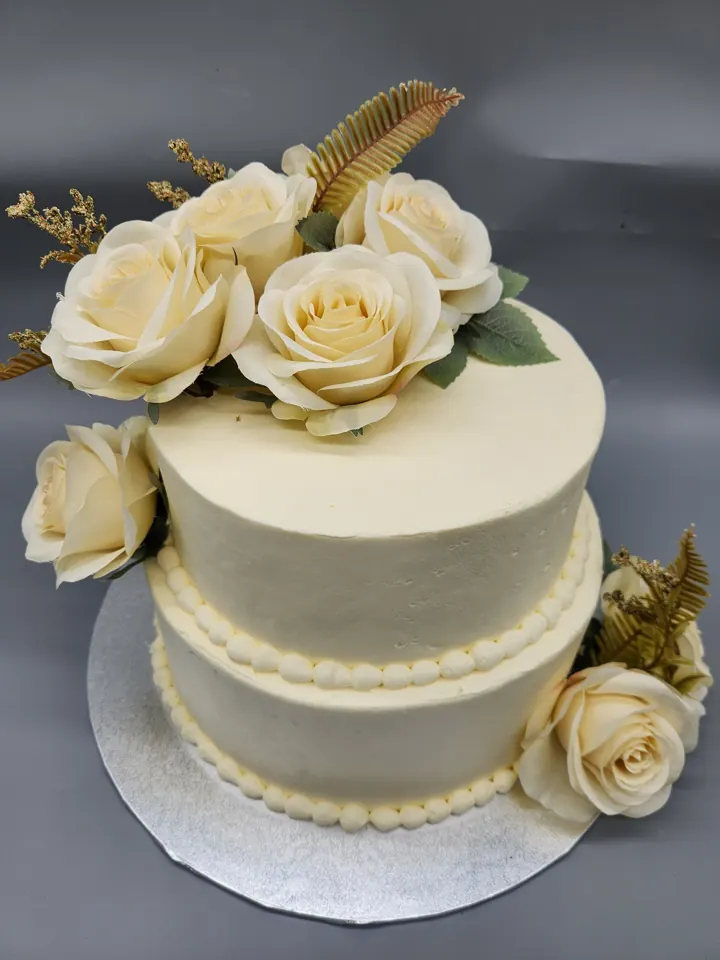 Two-tier white cake with cream roses