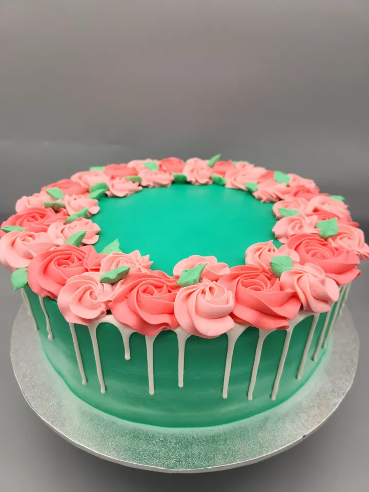 Teal drip cake with pink rosettes