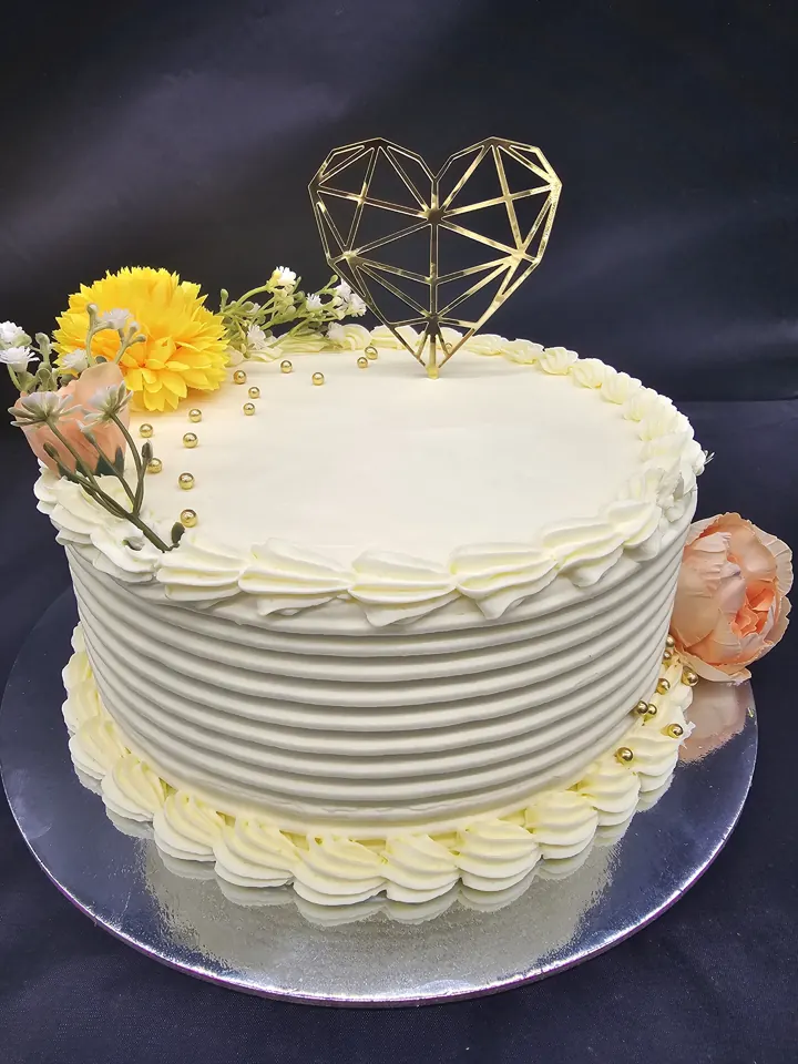 Textured white cake with gold heart topper