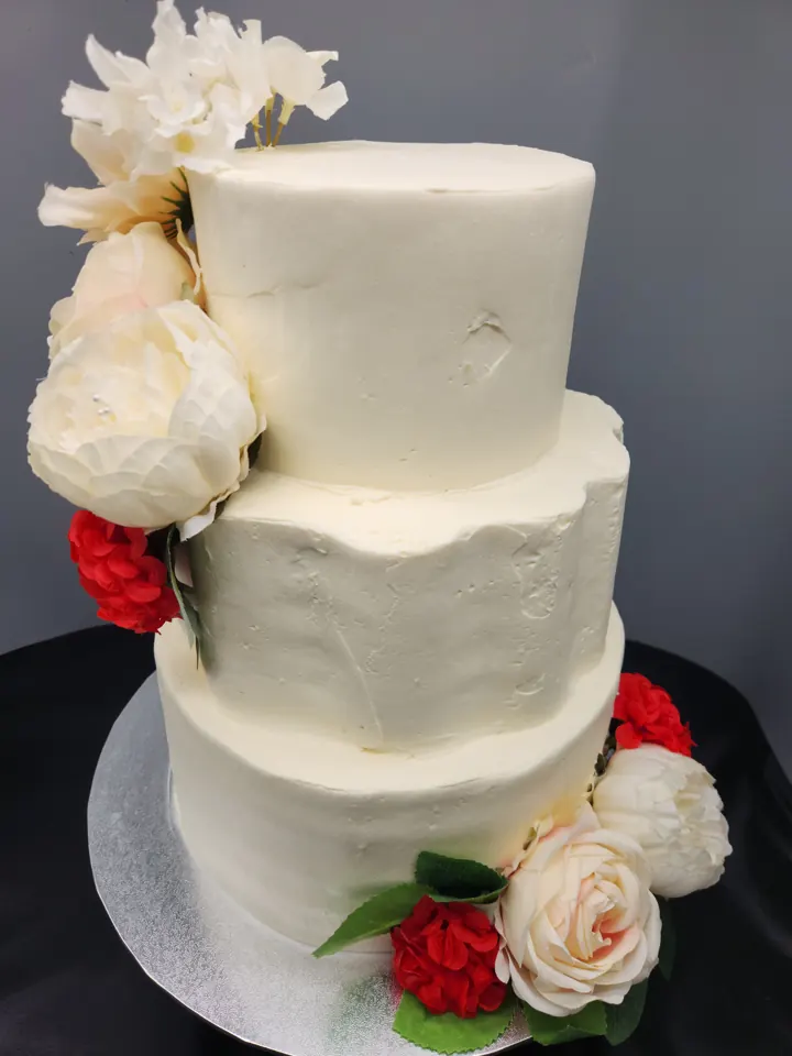 Three-tier white cake with fresh flowers